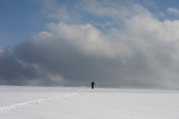 Man on ski track against cloudy sky