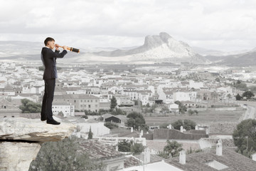 Businessman looks through a telescope