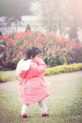 Cute little girl play in the flower garden in the soft style