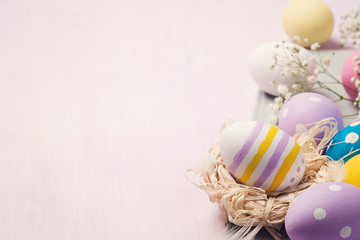 Colorful Easter eggs on a wooden table with space for text