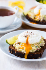 Avocado and feta smash on rye bread and poached  egg on top
