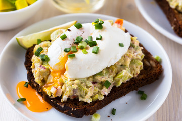 Avocado and feta smash on rye bread and poached  egg on top