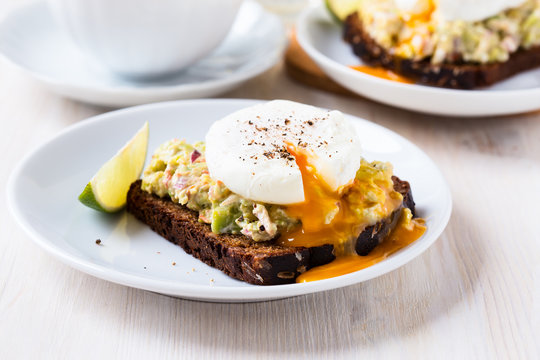 Avocado and feta smash on rye bread and poached  egg on top
