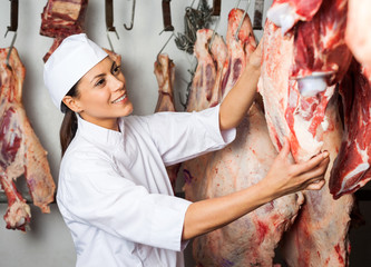 Butcher Testing Quality Of Meat Hanging