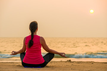 Fototapeta na wymiar woman in sportswear doing yoga at sunset