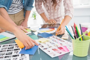 Fototapeta premium Coworkers briefing and editing photos together