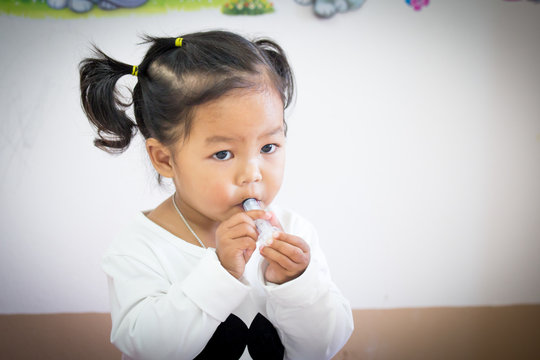 Sick Little Girl Giving Medicine Syringe By Herself