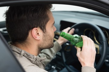 Man drinking beer while driving