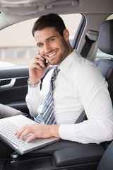 Businessman working in the drivers seat