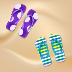 Colored beach slippers the sandy background