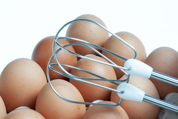 Oeufs et batteur électrique sur fond blanc