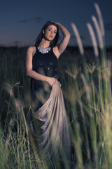 Obraz premium Woman in a field in the later afternoon posing 