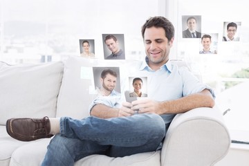 Cheerful man sitting on the couch using his smartphone