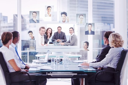 Composite image of group of business people looking at a screen