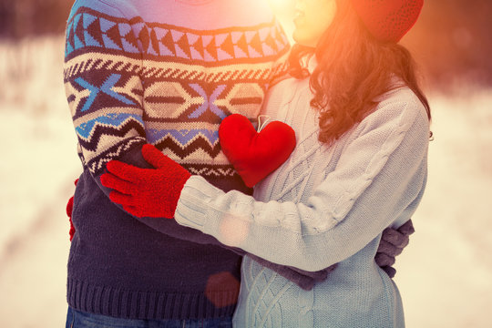 Young Couple Wearing Sweaters Holding Red Heart Outdoors In Wint