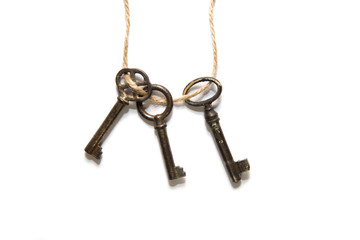 Three old keys tied with a rope on a white background