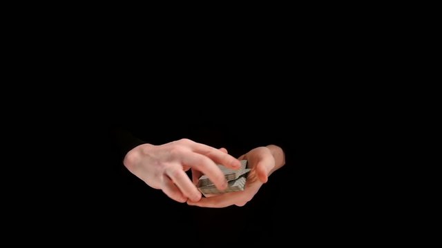 Amazing magician showing a trick with cards on black background