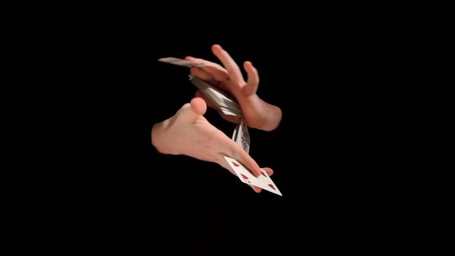 trick with playing cards on black background, slow motion