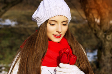 Spring portrait of a girl with red tulips