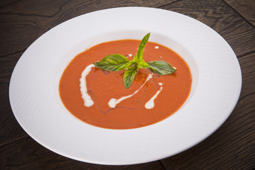 fresh tomato soup in a white bowl on wooden table