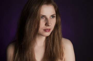 Girl with long natural ginger hair on purple background.
