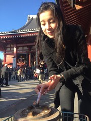 girl light up incense at asakusa shrine