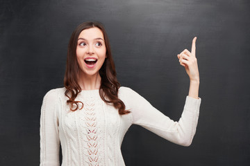 Funny cheerful woman pointing at chalkboard