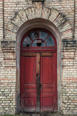 Fototapeta na wymiar Red old door in a brick wall