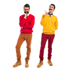 Twin brothers thinking over white background