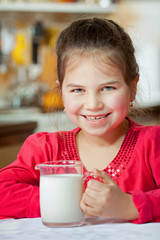 Little girl having milk for breakfast