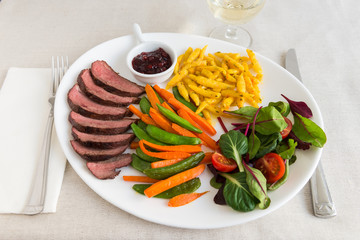 Roasted Duck Breast with berry sauce, spatzle and vegetables.
