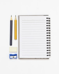 High angle shot of blank note book, pencil, sharpener