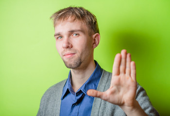 Man gesturing stop isolated on a yellow background