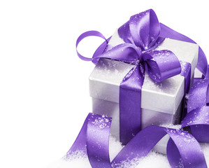 Gift box with a lilac bow on snow isolated on the white