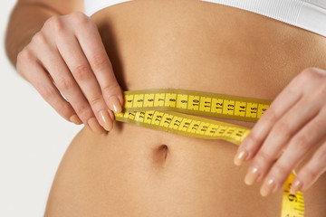 Close-Up Of Woman In Underwear Measuring Waist With Tape