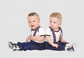 Year-old twins boys on grey backround