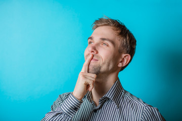 A young man in his middle  with his hand on his chin looks like he is thinking deeply about...