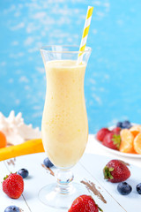 Delicious berry cocktail on table on water background