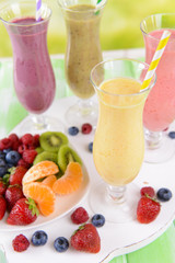 Delicious berry cocktails on table on bright background