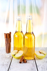 still life with apple cider and fresh apples on wooden table