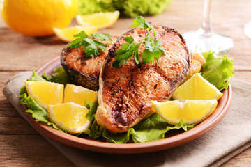 Tasty baked fish on plate on table close-up