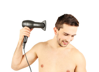 Handsome young man blow drying his hair isolated on white
