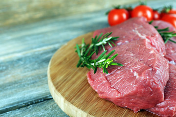 Raw beef steak with rosemary and cherry tomatoes