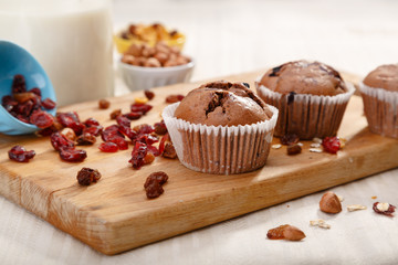Delicious chocolate muffins on wooden board 