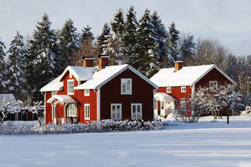 old red farm set in a wintery rural landscape, sweden