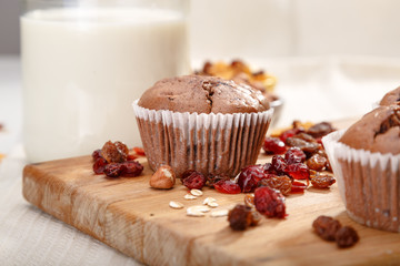 Delicious chocolate muffins on wooden board 