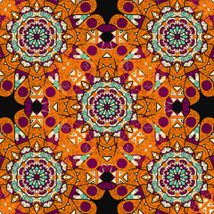 Seamless mandalatiled pattern in orange color over black