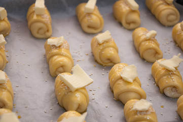 Mini croissants with cheese , sesame seeds and butter pieces