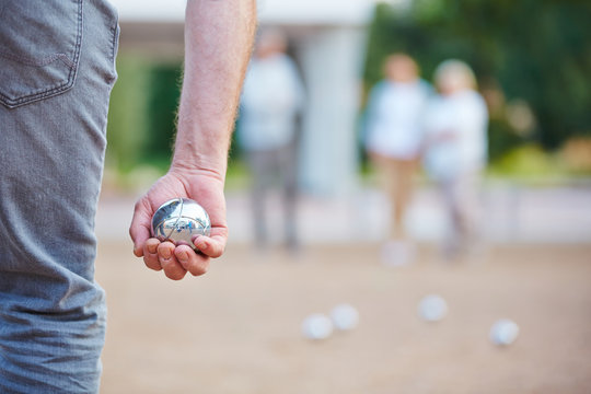 Hand h&auml;lt Kugel beim Spiel Boule