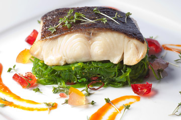 a piece of fried fish on white plate